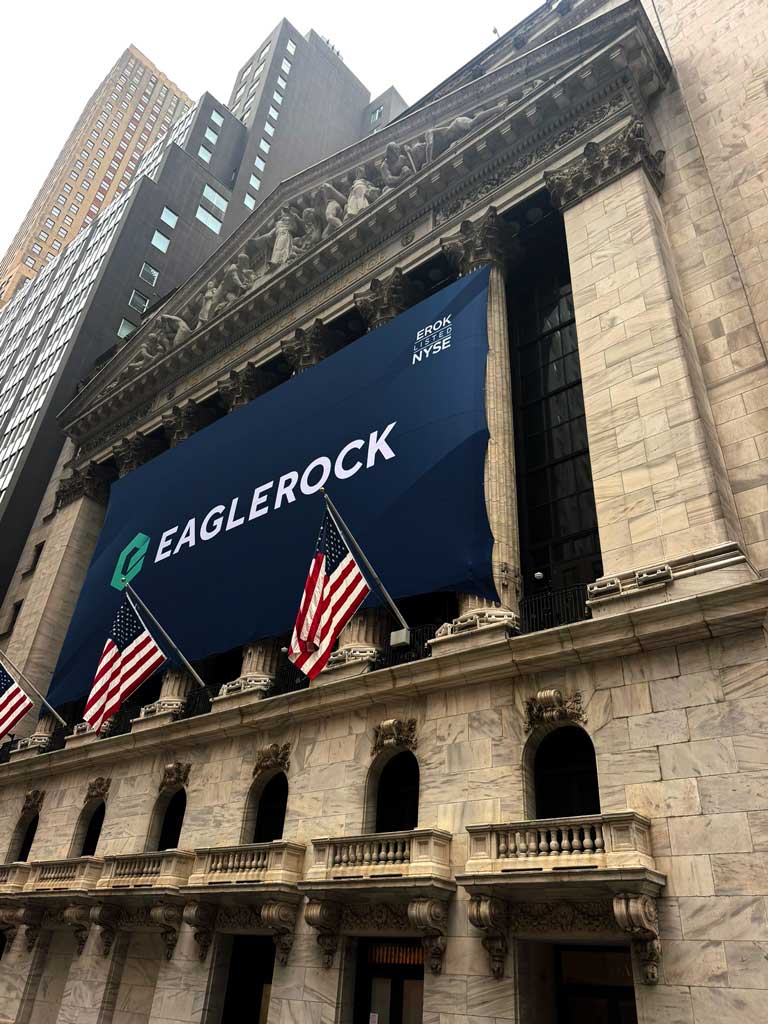 Exterior of the New York Stock Exchange on Wall Street, displaying the Eagle Rock banner and American flags